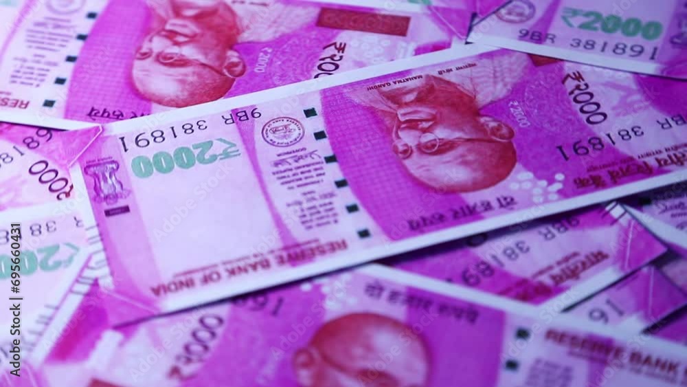 Poster camera panning 360 degrees around spread 2000 indian rupee notes. camera moving around scattered rup