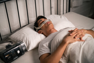 Asian man wearing cpap machine sleeping smoothly all night in bedroom.  - obrazy, fototapety, plakaty