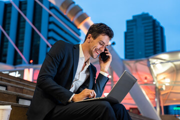 Caucasian businessman talk on mobile phone while work in city at night. 