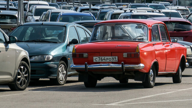 Retro automobile from USSR - AZLK Moskvich - 412 in red color on the parking - comparison of bright colors in old cars and dull colors in modern vehicles. S-Petersburg, Russia, 16.08.2019
