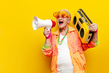 funny crazy old granny with tape recorder in sports hipster clothes listens to rock music and...