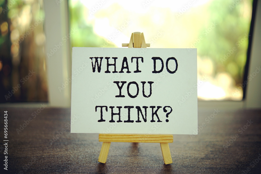 Aufkleber what do you think? text message on paper card with wooden easel