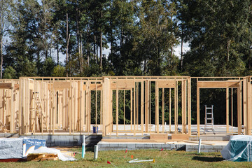 New construction house frame framing being built with a foundation and lumber