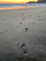 Fototapeta na wymiar 砂浜の足跡、砂浜を歩いた跡、砂浜についた裸足の後、素足で歩いた跡、由比ヶ浜海岸の足跡、海岸の足跡