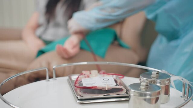 Doctor fumble blood vessel on arm of blood donor asian woman preparing steps during venipuncture to donation at hospital
