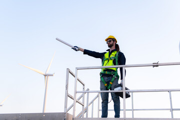 Engineer at natural energy wind turbine site with a mission to climb up to the wind turbine blades to inspect the operation of large wind turbines