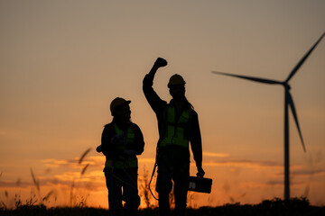 Fototapeta na wymiar Silhouette of Engineer in charge of wind energy against a background of wind turbines.