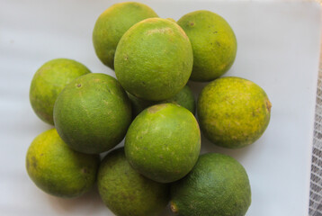 several whole limes on a white plate
