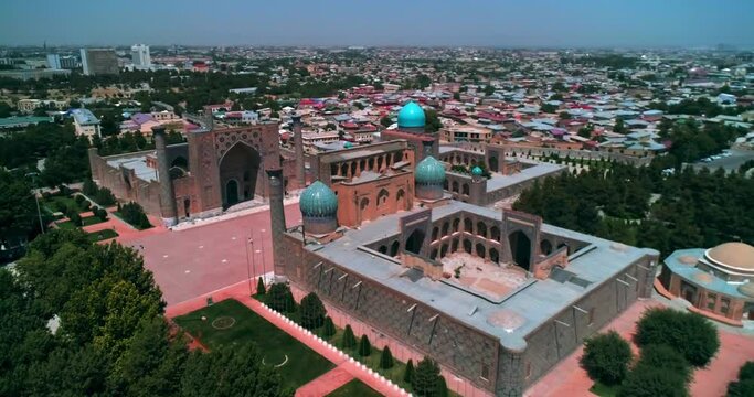 A drone flies over an ancient complex Bibi Khanym Mosque. Sunny summer day. Samarkand, Uzbekistan.