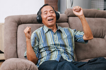 Asian old man  listens to music through headphones and dancing.