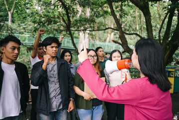 Woman activist leading the demonstrations, raising hands and holding megaphone