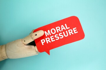 Hand holding a chat box with the word moral pressure. the concept of mental health