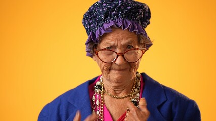 Closeup funny portrait of happy elderly toothless senior woman wearing glasses pointing fingers...