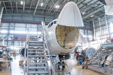 White passenger airliner under maintenance in the aviation hangar