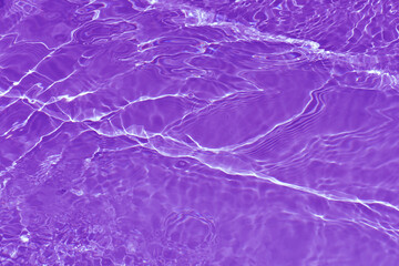 Fototapeta na wymiar Purple water waves on the surface ripples blur. Defocus blurred transparent pink colored clear calm water surface texture with splash and bubbles. Water waves with shining pattern texture background.
