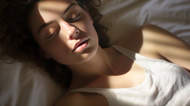 Photo of sleeping young woman lies in bed with eyes closed.,