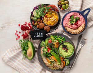 Vegan tasty hummus, herb hummus, beetroot hummus on a light wood background.