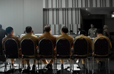 People Sitting in a Row, Waiting for Something