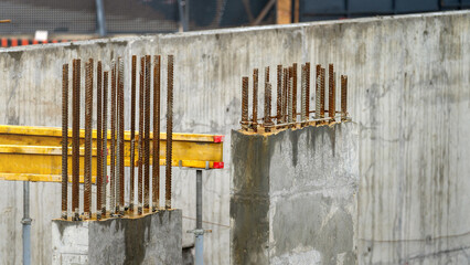 Rebar sticking out of concrete parts of house under construction close-up