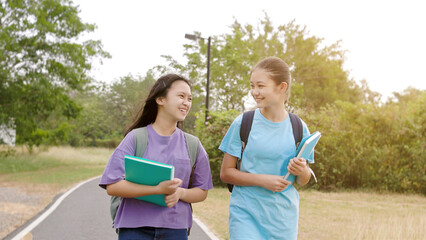 Happy  student girls walking and talking in the school