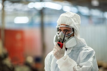 Male inspector team investigate danger chemical gas leak spill with safety face mask PPE suit in area closed barricade security tape. danger dirty area infected chemical leak spill cross stripe ribbon