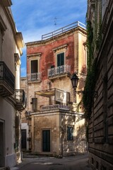 narrow alley with colourful shabby chic buildings in the old city center of Lecce
