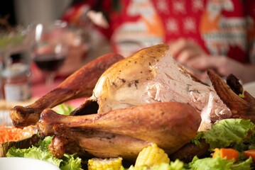 Turkey dinner Thanksgiving food. Man carry Christmas turkey food dinner Serve on table. Baked turkey chicken garnished with family Christmas tree and burning candles . Roasted turkey table setting