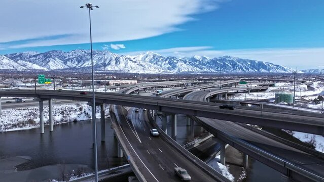 Drone view of traffic on spaghetti bowl in Salt Lake City, snowy mountains