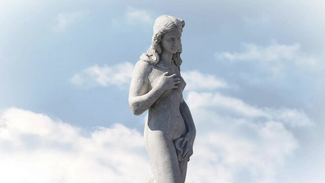 Animation of gray sculpture of woman over blue sky and clouds