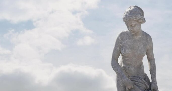 Animation of gray sculpture of woman over blue sky and clouds, copy space