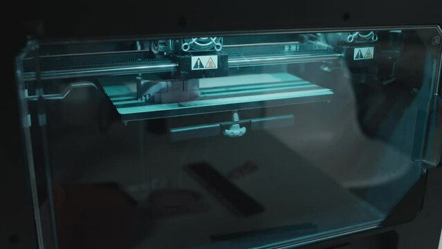 Close-up shot of 3D printing machine making prototype model from resin material