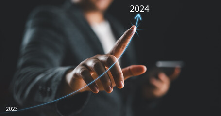 Businessman hand drawing line for increasing arrow from 2023 to 2024 for preparation merry...