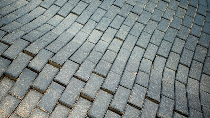 Defect in the road surface of artificial paving stones. Damage to the road surface.