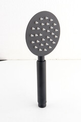 The black hand shower features a sleek, modern design that adds a stylish touch to any bathroom.