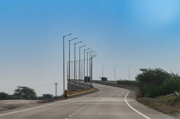 Flyover on the road connecting Jaisalmer and Jodhpur, Rajasthan, India. National Highway 68, NH 68. Bly sky above.