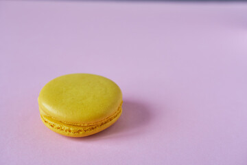 Yellow macaroon on a pink background. Minimal style.