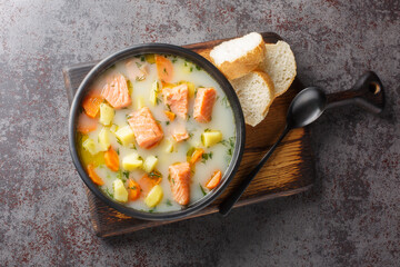 Lohikeitto, salmon fish soup with cream, potato, carrots, leek and dill closeup in a bowl on the...