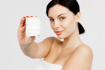 A beautiful young Caucasian woman with brown hair uses a cotton pad. The concept of advertising facial care, cosmetic natural products.