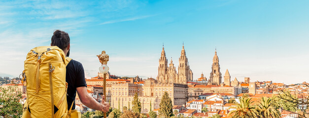 Pilgrim on the Camino de Santiago (Saint James way) looking at the cathedral and the old town panoramic view of Santiago de Compostela, Galicia, Spain - obrazy, fototapety, plakaty