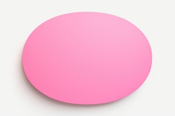 A pink circular object is placed on a white surface. This versatile image can be used for various purposes