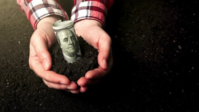Man holding soil with dollars. Human hands holding soil with growing money. Money growth and dividend interest, planning future investment. Financial growth and business management ideas.