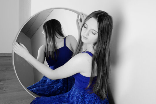 young woman looks in the mirror - art photo