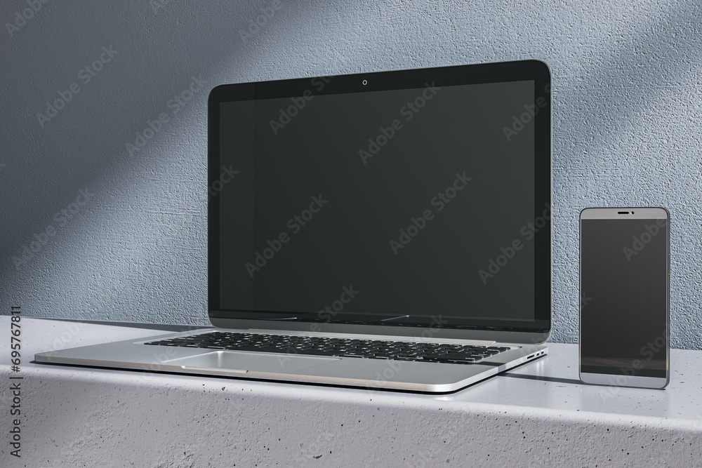 Aufkleber close up of empty laptop and mobile phone on gray desk. concrete wall background. device presentatio