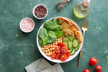 Bowl with grilled Halloumi cheese, spinach, chickpeas, tomatoes and cucumbers. Healthy eating....