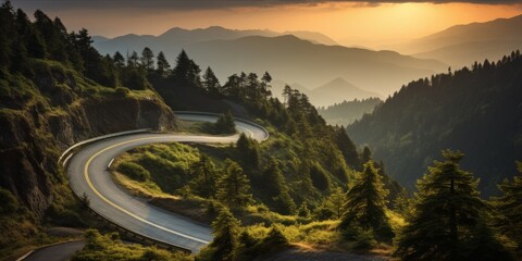 A winding road through a forested mountain area at sunset.