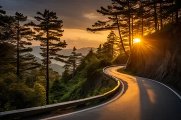 Foto op Canvas A winding road through a forested mountain area at sunset. © ParinApril
