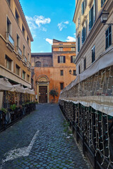 Rue pavée bordée de terrasses de restaurants à Rome
