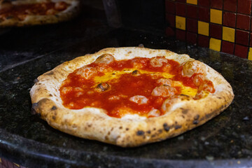 Pizza a portafoglio tradizionale napoletana condita con sugo di pomodoro e olio d'oliva appena sfornata e pronta per essere chiusa e venduta