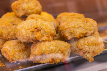 Frittatine di pasta fritte tradizionali napoletane esposte in una vetrina da vendita dio una pizzeria