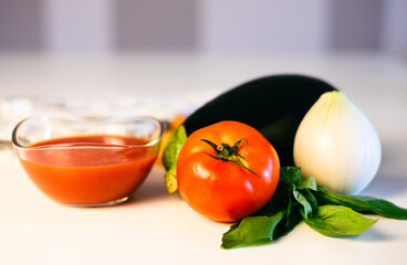 Ingredients on white table for making Italian pasta alla norma, traditional recipe with tomato, eggplant and onion. Healthy eating, Mediterranean diet